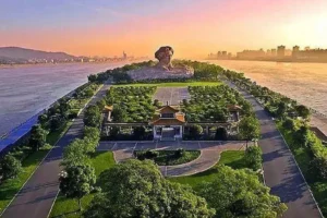 Sunrise over the Orange Island sculpture in Changsha, with orange trees in the foreground