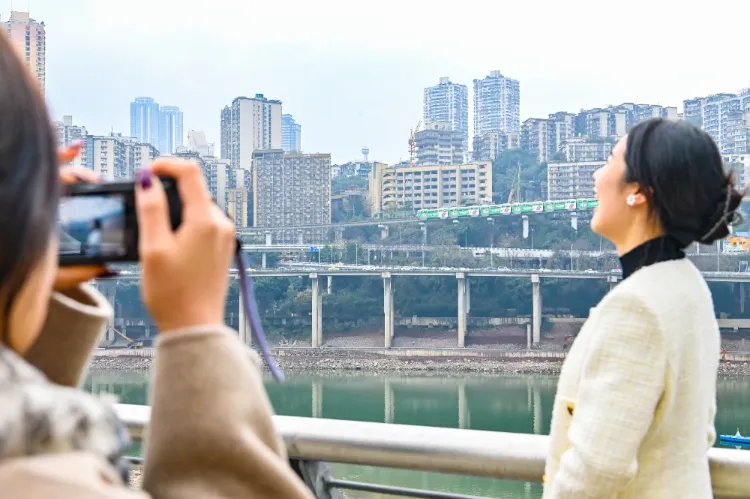 Animated picture of Liziba light rail passing through a building. The train roars out from the belly of a residential building, and tourists pose for dislocated photos of swallowing the light rail downstairs