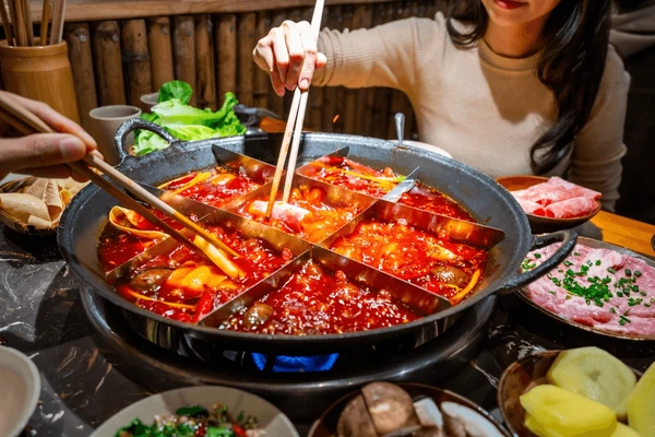 Sizzling nine-grid Chongqing hot pot with hesitant tourists